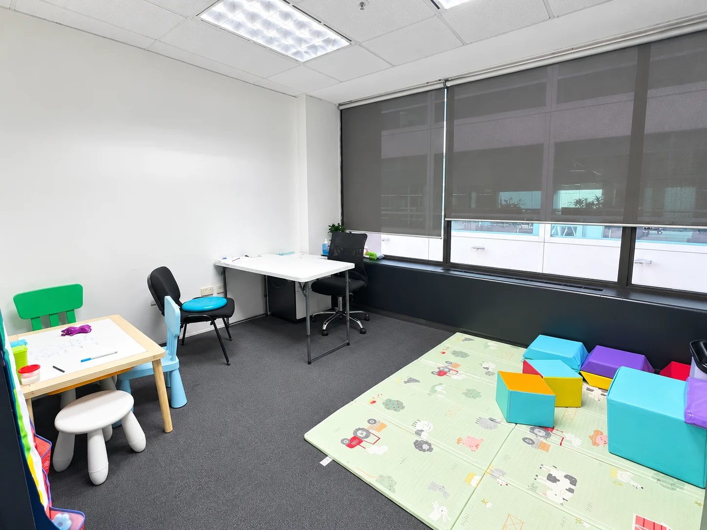 Our clinic therapy room with a play mat and children’s activity table